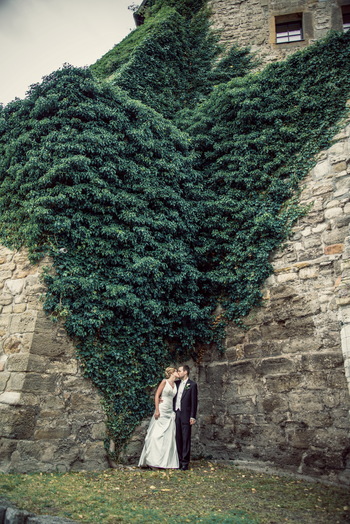 Und noch ein tolles Foto vom Brautpaar. Im Hintergrund ist die Burgmauer voll von Efeu.